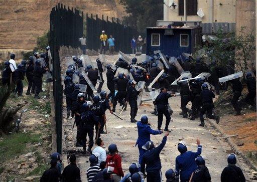 Policiers algériens sous des jets de pierres lors d'une manifestation près 